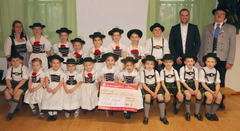 Unser Bild zeigt bei der Scheckübergabe die Jugendleiterin Jenny Bernhart (links), den Ersten Vorstand Georg Waldinger (rechts) und den stellvertretenden Marktbereichsleiter Matthias Buchner; dazwischen die neu ausgestatteten Trachtlerkinder des G.T.E.V. „Edelweiß“.