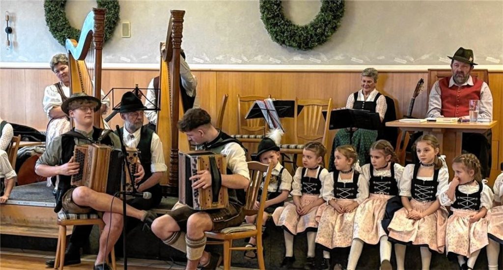 Die Ampfinger Hausmusi (hinten auf der Bühne sowie Sprecher Hans Auer) lauschen dem Spiel von Jakob (links) und Florian auf der Ziach. Foto stettner